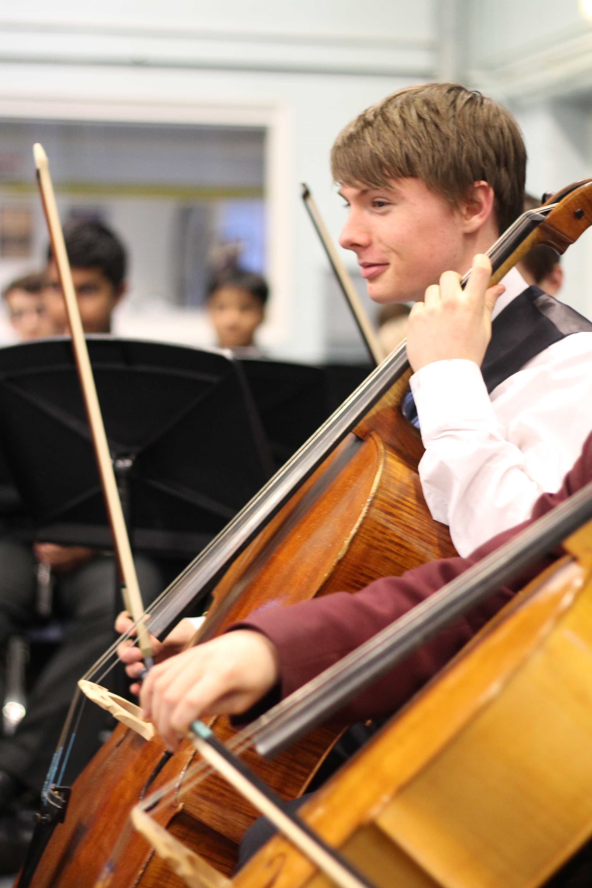 A young cellist playing in a school orchestra.