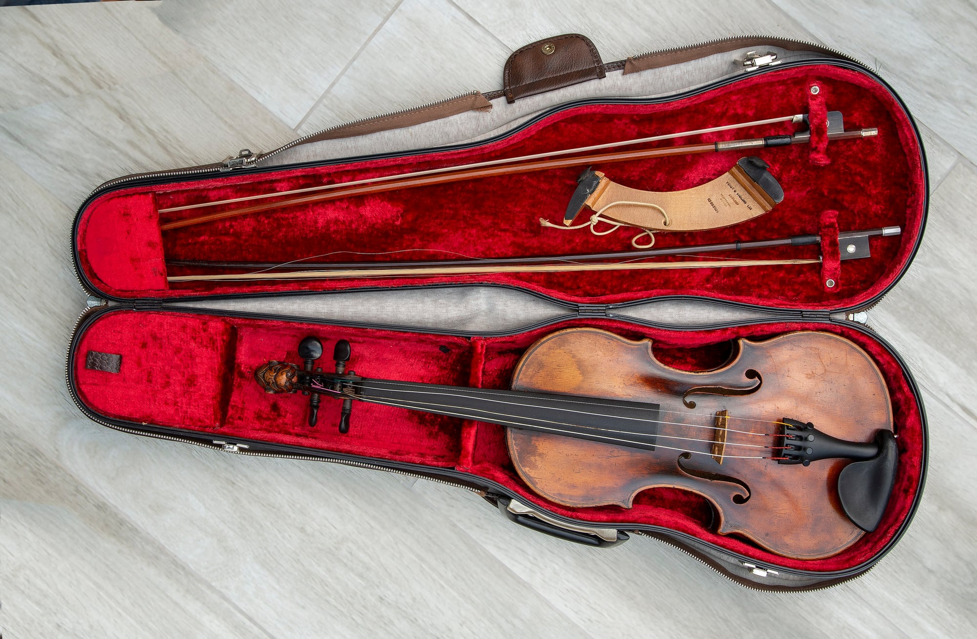 A violin and its bow packed into an open case.