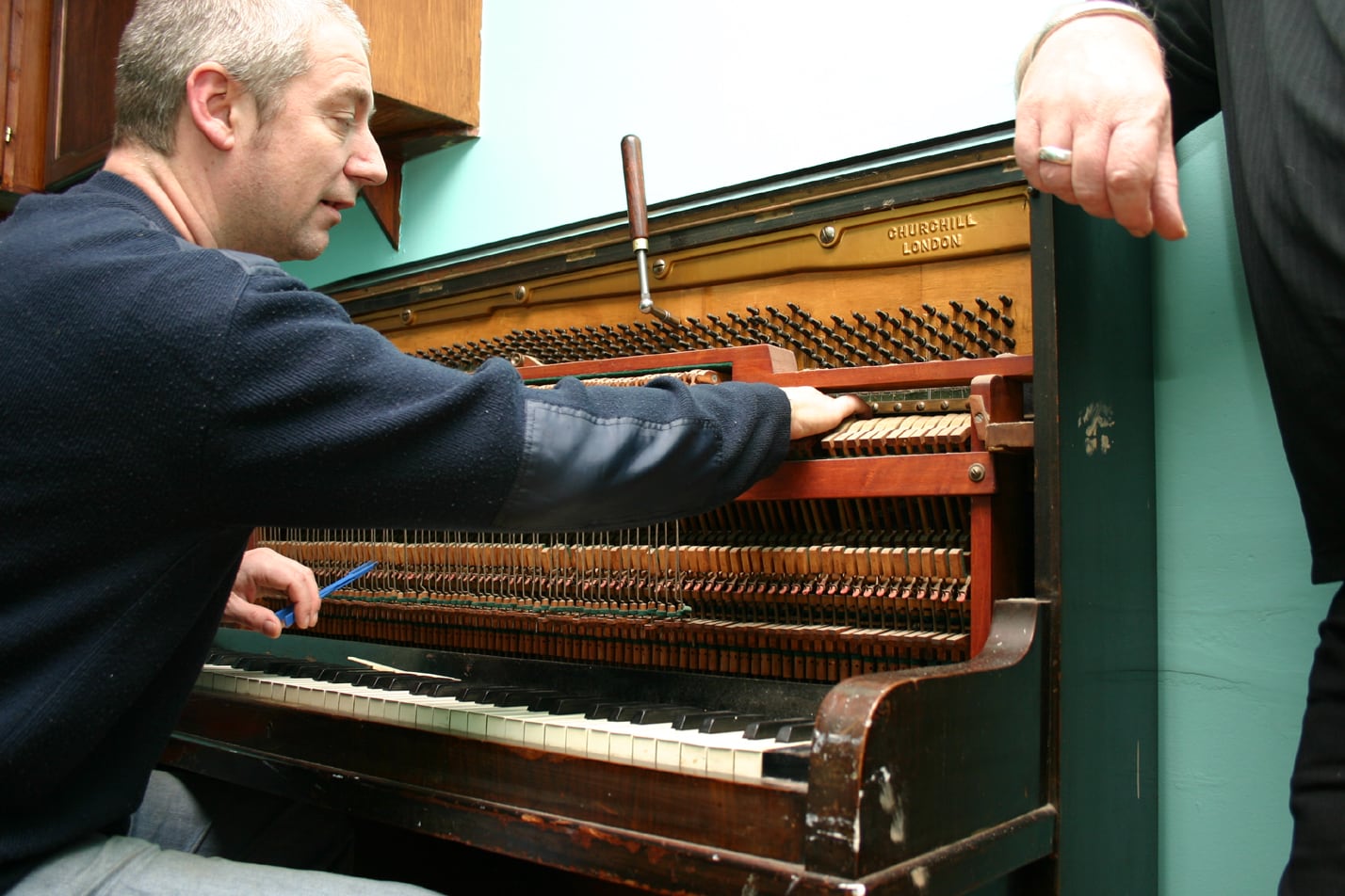 A technician working inside a piano.
